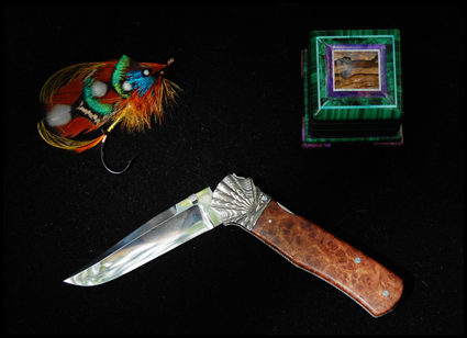 Handmade fishing fly by Ken Rowe; malachite intarsia box by Nicolai Medvedev; Damascus knife by Ken Steigerwalt of Rowe Gallery